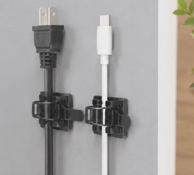 Pack of 25 Problems Solved 3M self-adhesive cable organizers for desk, showing cable management clips attached to a workspace.