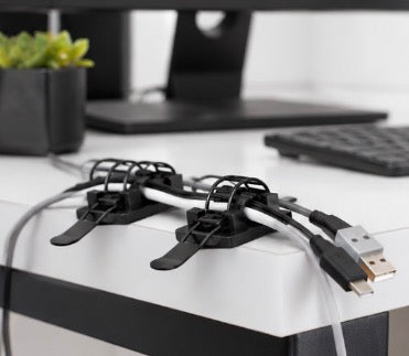 Pack of 25 Problems Solved 3M self-adhesive cable organizers for desk, neatly bundling and managing cords and cables.