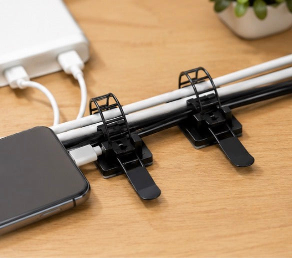 Pack of 25 Problems Solved 3M self-adhesive cable organizers for desks, showing black cable clips attached to a desk surface.