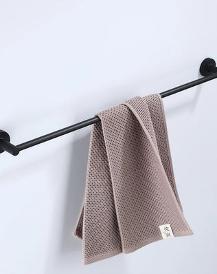 Black bathroom hardware set including robe hook, towel rail, bar rack, shelf, and tissue paper holder by Problems Solved