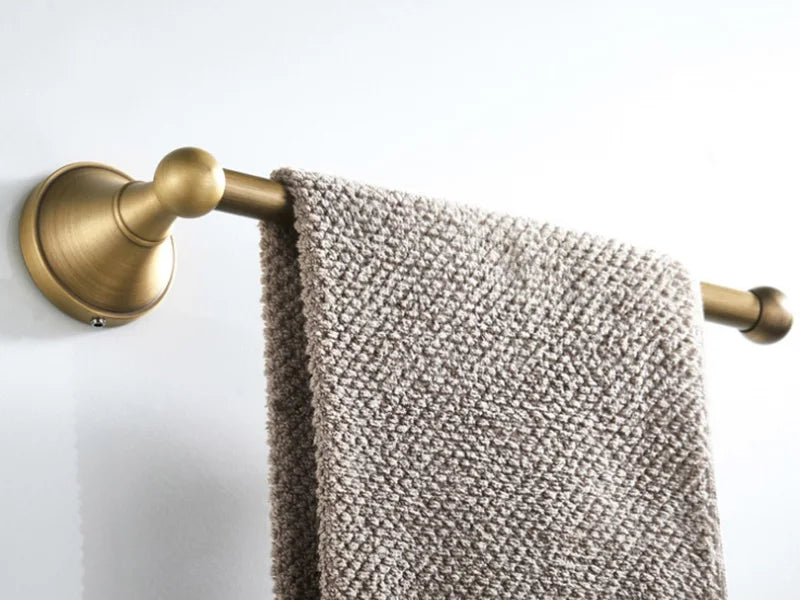 Antique brass wall-mounted toilet paper holder with a classic design, suitable for bathroom accessories by Problems Solved.