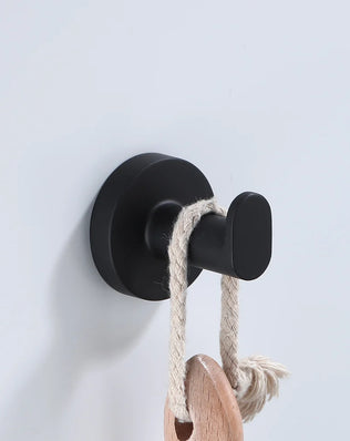Black bathroom hardware set including robe hook, towel rail, bar rack, shelf, and tissue paper holder by Problems Solved