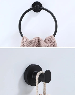Black bathroom hardware set including robe hook, towel rail, bar rack, shelf, and tissue paper holder by Problems Solved