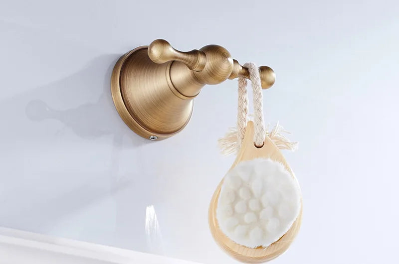 Antique brass wall-mounted toilet paper holder with a vintage design, suitable for bathroom accessories by Problems Solved.