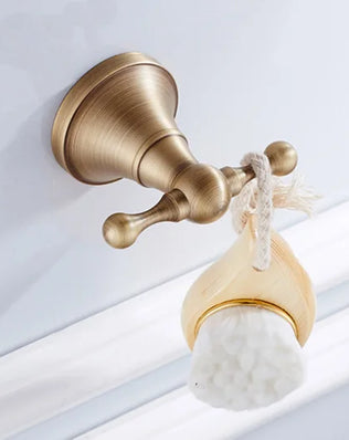 Antique brass wall-mounted toilet paper holder from Problems Solved, showcasing a classic bathroom accessory design.