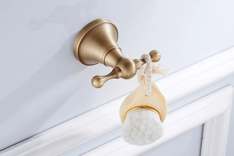 Antique brass wall-mounted toilet paper holder from Problems Solved, showcasing a classic bathroom accessory design.