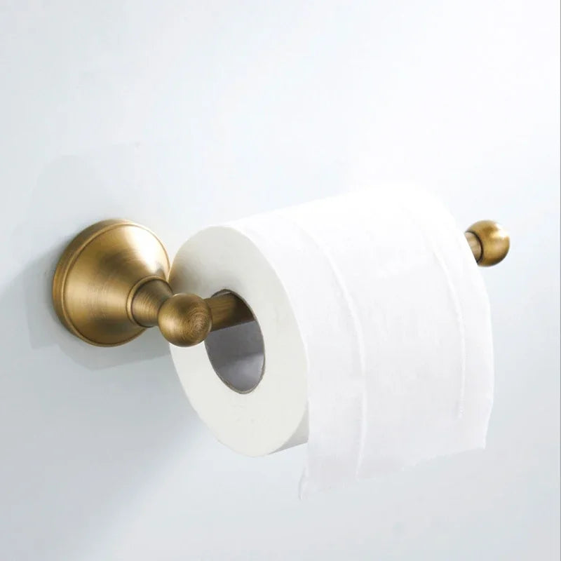 Antique brass wall-mounted toilet paper holder from Problems Solved bathroom accessories set, featuring classic design and sturdy metal construction.